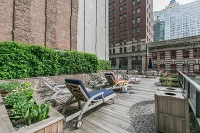 a deck with chairs and plants on a building at Tribeca Studio w Tons of light Gym Pool NYC-118 in New York