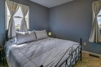 a bedroom with a bed with blue walls and a window at Upstate New York Vacation Rental Near Cooperstown! in Cherry Valley