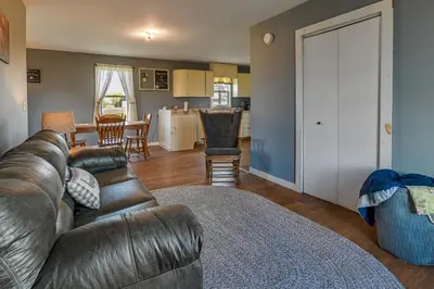 a living room with a leather couch and a kitchen at Upstate New York Vacation Rental Near Cooperstown! in Cherry Valley