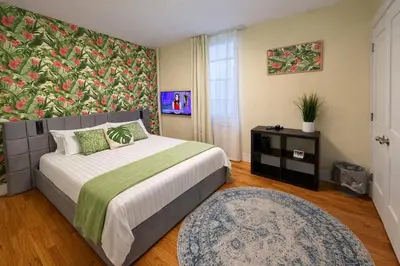 a bedroom with a bed with a floral wall at Tropical style room in Geusthouse in New York