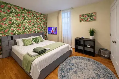 a bedroom with a large bed with a floral wall at Tropical style room in Geusthouse in New York