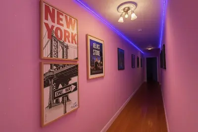a hallway with posters on a pink wall at Tropical style room in Geusthouse in New York