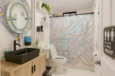 a bathroom with a sink and a map shower curtain at Tropical style room in Geusthouse in New York