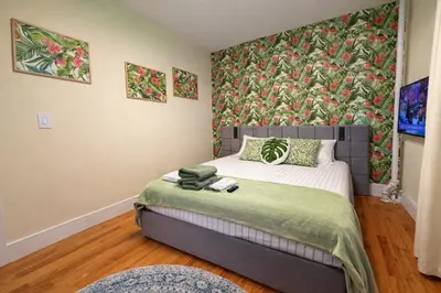 a bedroom with a bed with a floral wallpaper at Tropical style room in Geusthouse in New York