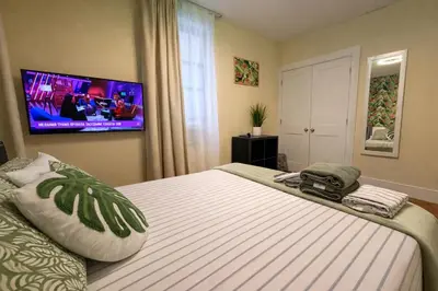 a bedroom with a bed with a tv on the wall at Tropical style room in Geusthouse in New York
