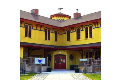 a large yellow building with a red door at Walk to the Outfield of Lime Rock Park in Salisbury