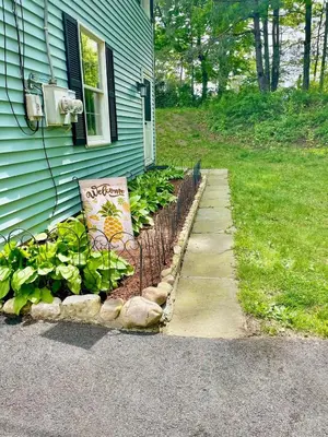 a garden in front of a house with plants at Walk to the Outfield of Lime Rock Park in Salisbury