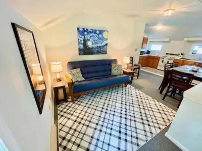 a living room with a blue couch and a kitchen at Walk to the Outfield of Lime Rock Park in Salisbury