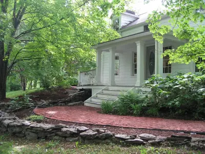 a white house with a stone walkway in front of it at B&B on seven acres with private bed & bath in Clinton Corners