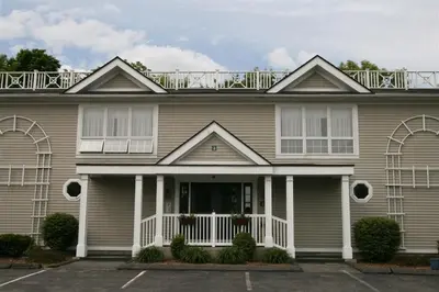 a house with a balcony on top of it at The Central Downtown Inn Suites in Pittsfield