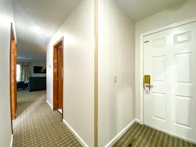 a hallway with a white door and a room at The Central Downtown Inn Suites in Pittsfield