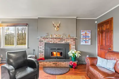 a living room with a fireplace with a chair and a couch at North Shire Lodge in Manchester
