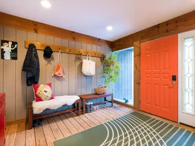 a living room with a red door and a rug at Catskills Escape - Serenity on 105 Acres, 2 hours from NYC in Ellenville