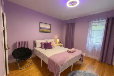 a bedroom with purple walls and a bed and a chair at Lavender style Room in Geusthouse in New York