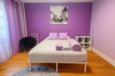 a bedroom with a bed with purple walls at Lavender style Room in Geusthouse in New York