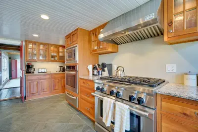 a kitchen with wooden cabinets and a stove top oven at Serene Retreat Near Mt Snow Great for Groups! in Marlboro