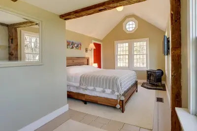 a bedroom with a bed and a tv and windows at Serene Retreat Near Mt Snow Great for Groups! in Marlboro