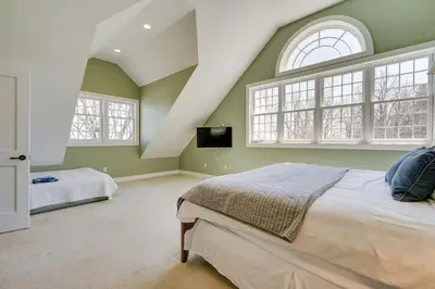 a bedroom with green walls and a bed and windows at Serene Retreat Near Mt Snow Great for Groups! in Marlboro