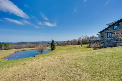 an old stone house on a hill next to a pond at Wellness Retreat with Views! Upscale Marlboro Cabin in Marlboro