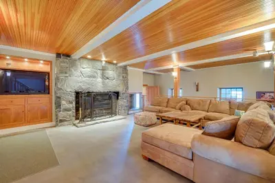 a living room with a couch and a stone fireplace at Wellness Retreat with Views! Upscale Marlboro Cabin in Marlboro