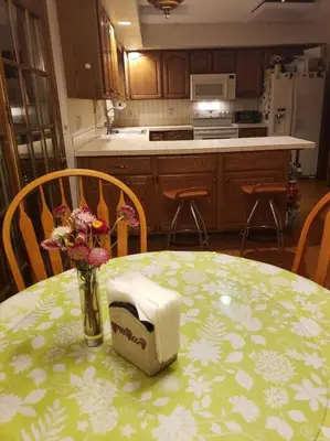 a kitchen with a table with a vase of flowers on it at Charming mountain view country house in Cheshire