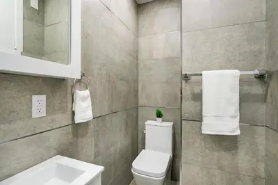 a bathroom with a toilet and a sink at 48-3RW Brand New 1BR Prime Hells Kitchen - W D in New York