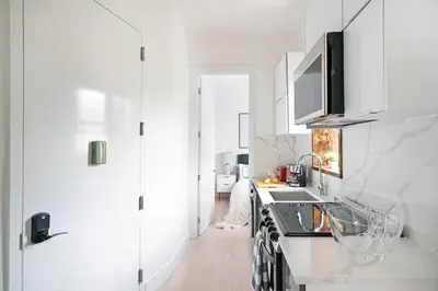 a white kitchen with a sink and a stove at 48-5FE Brand New 2BR in prime Midtown in New York
