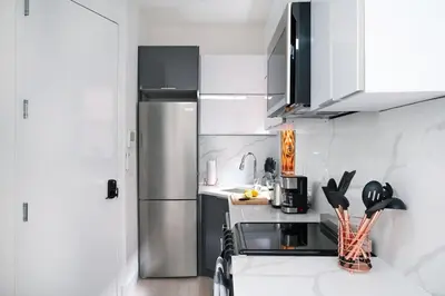 a kitchen with a stainless steel refrigerator and white cabinets at 48-5RW 1BR Apartment in Midtown West W D in New York