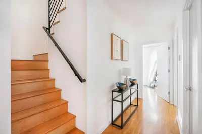 a hallway with white walls and a staircase with wood floors at 13-3 I Brand New 4BR 3 Baths Duplex Private Roof Deck in New York