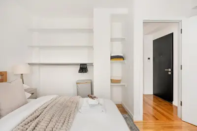 a white bed in a room with a black door at 13-3 I Brand New 4BR 3 Baths Duplex Private Roof Deck in New York
