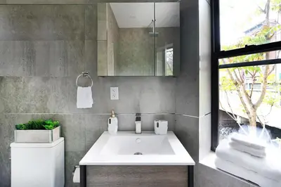 a bathroom with a white sink and a mirror at 48-1FE Brand New 1BR Prime hell's kitchen WD in unit in New York