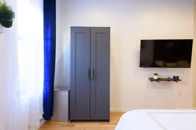 a blue door in a bedroom with a tv at 83-3W UES Central Park Newly Furnished XL Studio in New York