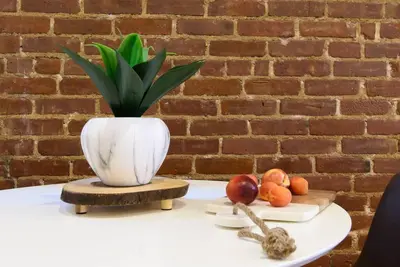a white vase sitting on top of a table with fruit at 83-3W UES Central Park Newly Furnished XL Studio in New York