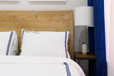 a bedroom with a bed with a wooden headboard and a lamp at 1597-9 Renovated Studio Prime UES WD in unit in New York