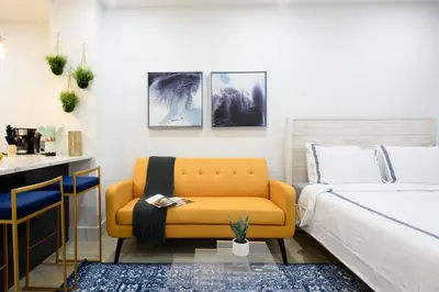 a bedroom with a bed and a yellow couch at 1597-9 Renovated Studio Prime UES WD in unit in New York
