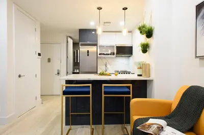 a kitchen with a counter and some chairs in a room at 1597-9 Renovated Studio Prime UES WD in unit in New York