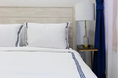 a bed with white pillows and a lamp on a table at 1597-9 Renovated Studio Prime UES WD in unit in New York