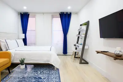 a bedroom with a bed and a flat screen tv at 1597-9 Renovated Studio Prime UES WD in unit in New York