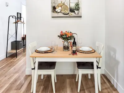 a dining room table with chairs and a vase of flowers at Stylish studio in Bristol, newly renovated! in Bristol