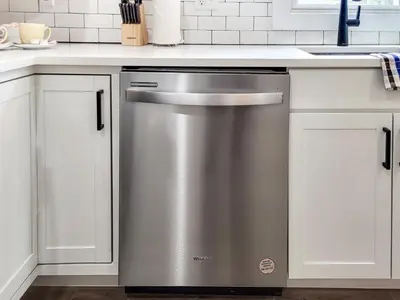 a stainless steel dishwasher in a kitchen with white cabinets at Stylish studio in Bristol, newly renovated! in Bristol