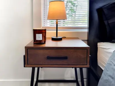 a nightstand with a lamp on it next to a bed at Stylish studio in Bristol, newly renovated! in Bristol