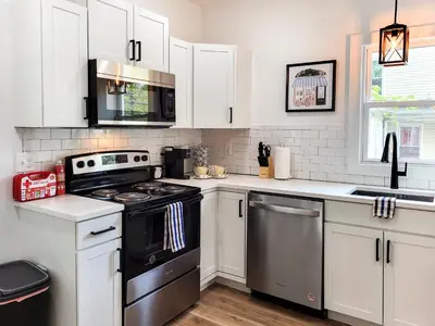 a kitchen with white cabinets and a black stove top oven at Stylish studio in Bristol, newly renovated! in Bristol