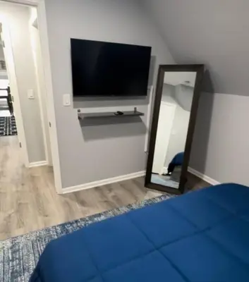 a bedroom with a tv and a mirror and a bed at Cozy Studio with 1 Bed & Comfy Sofa Bed in New Rochelle