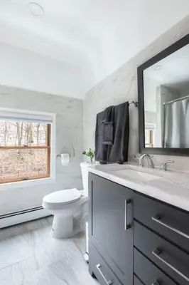 a bathroom with a toilet and a sink and a mirror at Cozy Studio with 1 Bed & Comfy Sofa Bed in New Rochelle