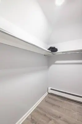 a room with a white wall and a wooden floor at Cozy Studio with 1 Bed & Comfy Sofa Bed in New Rochelle