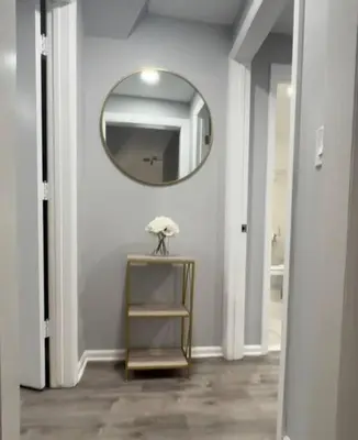 a hallway with a mirror and a table with a shelf at Cozy Studio with 1 Bed & Comfy Sofa Bed in New Rochelle