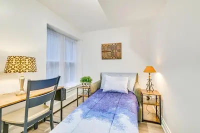 a bed in a room with a desk and a table at Walk to Downtown Albany Ten Broeck Triangle Apt! in Albany