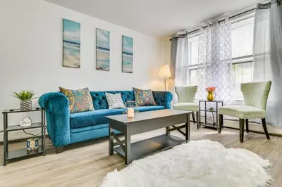 a living room with a blue couch and two chairs at Walk to Downtown Albany Ten Broeck Triangle Apt! in Albany