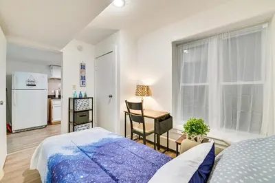 a bedroom with a bed and a desk and a window at Walk to Downtown Albany Ten Broeck Triangle Apt! in Albany