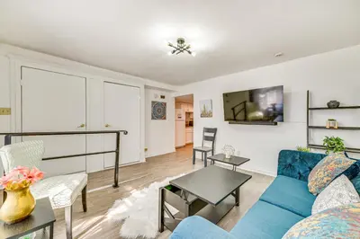 a living room with a blue couch and a tv at Walk to Downtown Albany Ten Broeck Triangle Apt! in Albany